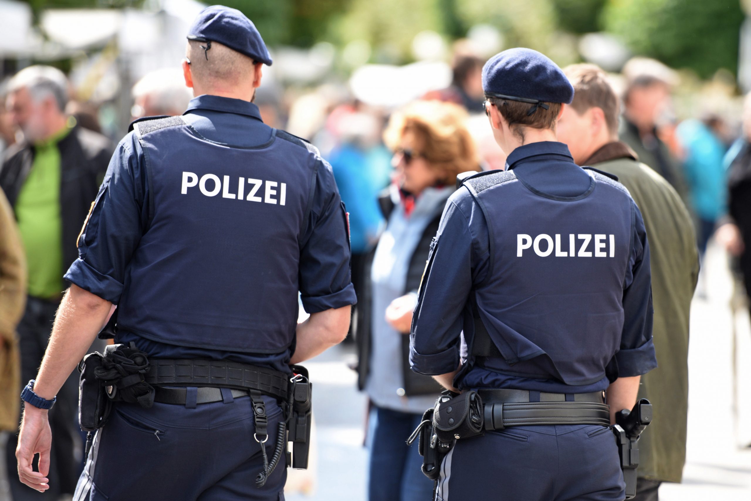 Zwei Polizisten vor Menschenmenge
